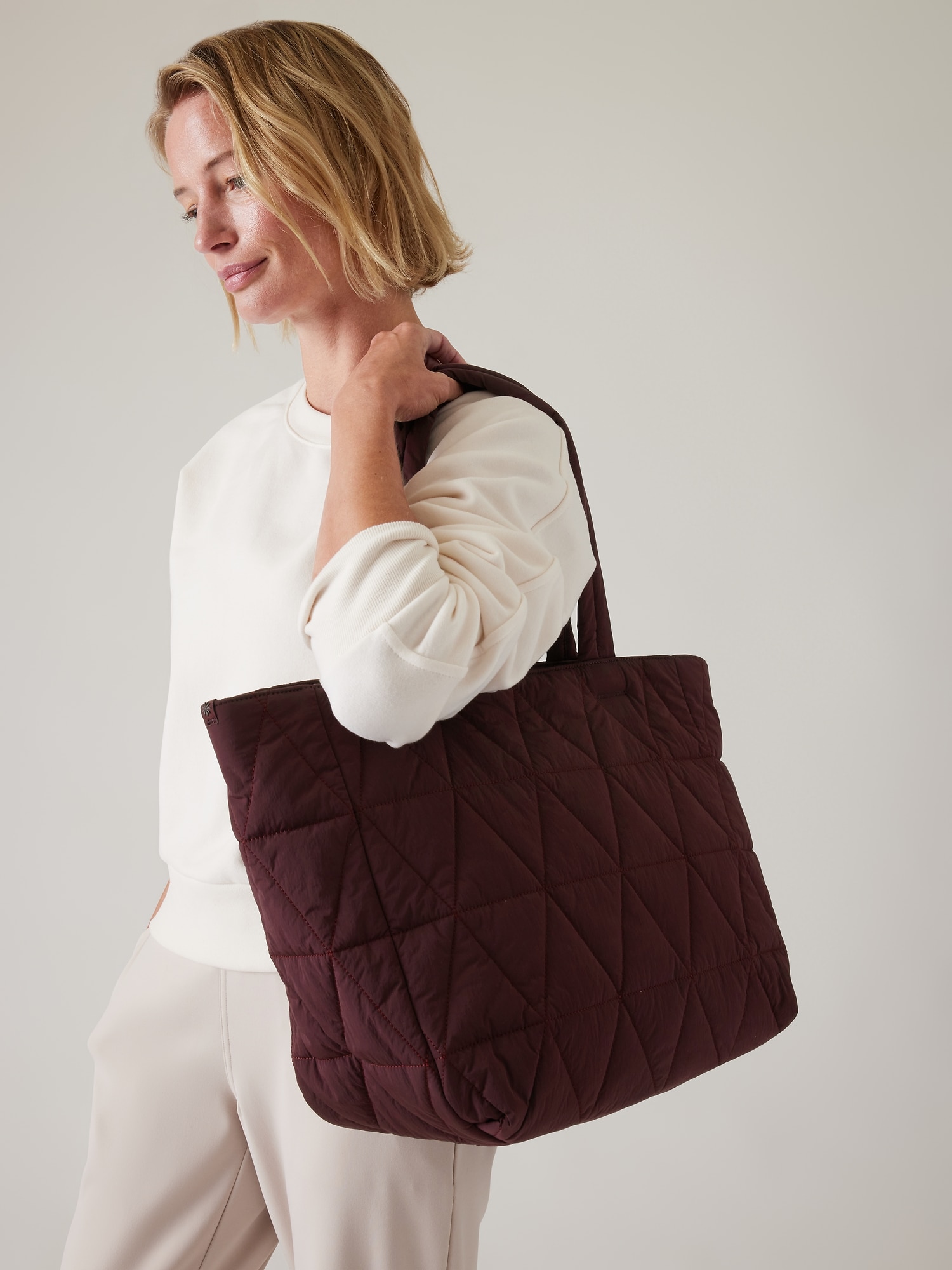 Pair this quilted tote bag with outfits featuring sporty stripes
